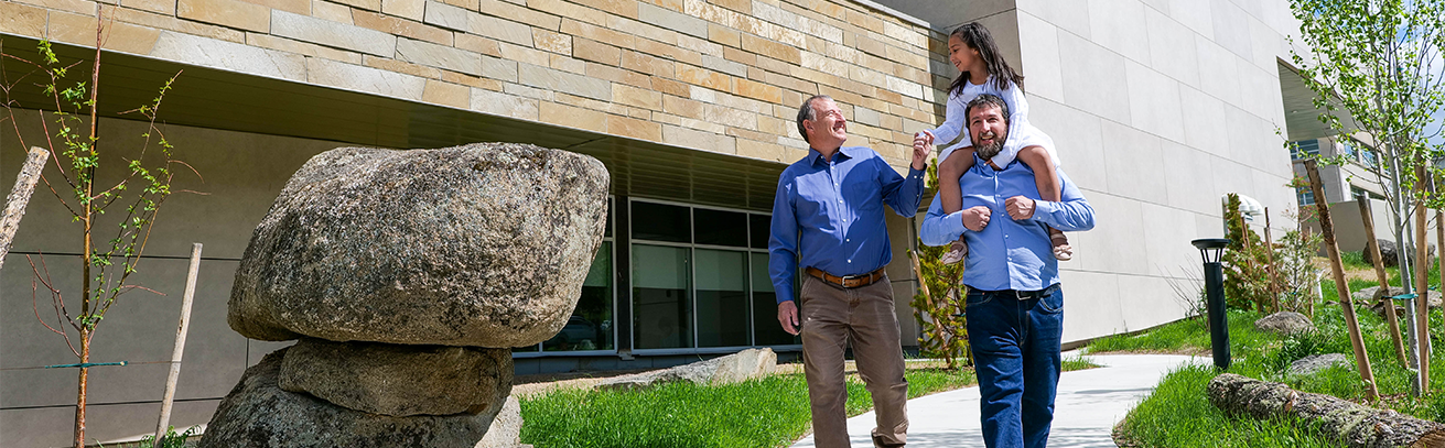 A family enjoys a walk outside the Montana Heritage Center.