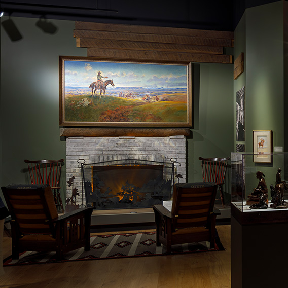 An image of the Mackay Mantle that Charles M. Russell branded his signature bullhead into. Above the mantle is the piece titled "Charles M. Russell and his Friends"