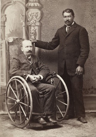 Vintage photo of a gentleman in a wheelchair with an atendant