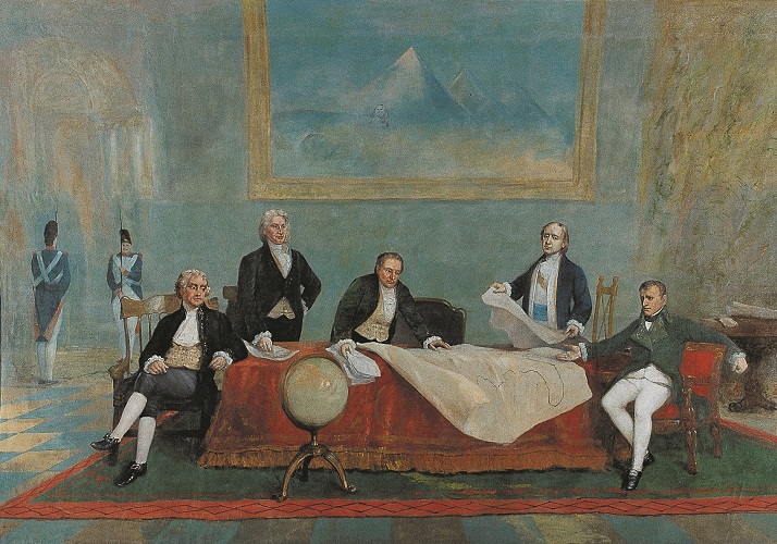 The painting "The Signing of the Louisiana Purchase." French state officials stand in the center of the painting, examining a map placed on a desk, while Thomas Jefferson and Napoleon Bonaparte are seated off to the left and right, respectively. A globe is placed in front of the desk, and in the background of the painting is a painting of the Egyptian Sphinx and pyramids.